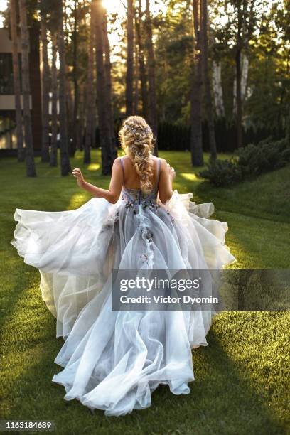 the bride in a flying dress in the evening sun. - boho wedding dresses stock pictures, royalty-free photos & images