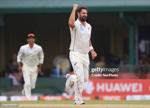 New Zealand cricketer Colin de Grandhomme celebrates after taking the wicket of Sri Lankan cricketer Kusal Mendis during the first day's play of the...