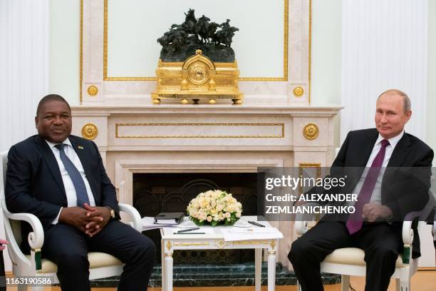 Russian President Vladimir Putin and Mozambique's President Filipe Nyusi pose for pictures prior to their meeting at the Kremlin in Moscow on August...