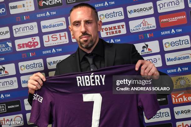 French midfielder Franck Ribery holds his new jersey during a press conference held for his presentation as a new player of Fiorentina, at the...