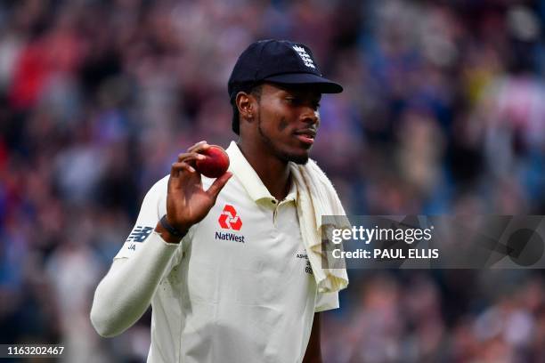 England's Jofra Archer holds up the ball as he leads off the England team after taking six wickets on the first day of the third Ashes cricket Test...