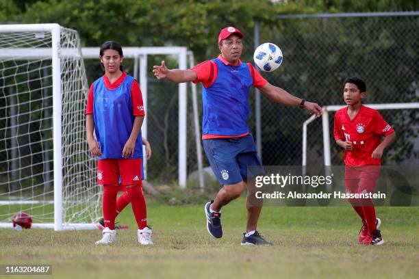 Giovanni Elber of FC Bayern Muenchen plays the ball with young soccer players as he visit the "Freekick Soccer" program inspired by DeAndre Hokins of...