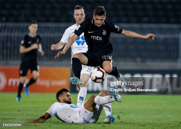 Filip Stevanovic of Partizan jumps over Etzaz Hussain of Molde during the UEFA Europa League Play Off First Leg match between Partizan Belgrade and...