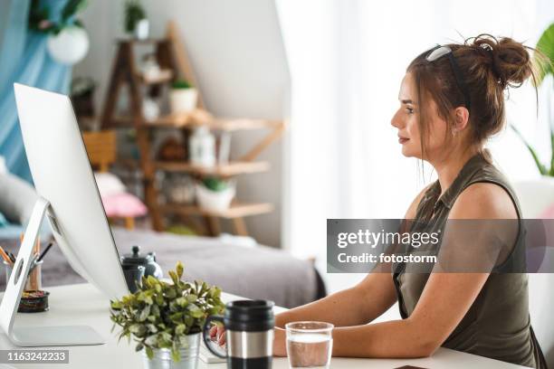 woman using computer at home office - posture stock pictures, royalty-free photos & images