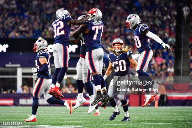 Devin McCourty celebrates with teammate Michael Bennett of the New England Patriots after completing a sack in the second quarter of a preseason game...