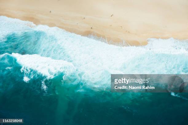 north shore, hawaii - aerial view of surf waves, blue sea water crashing on a sandy beach - beach sand and water hawaii stock-fotos und bilder