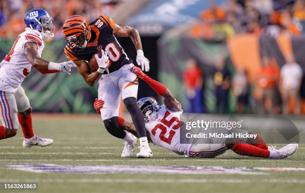 Josh Malone of the Cincinnati Bengals runs the ball after a catch as Corey Ballentine of the New York Giants tries to make the stop during the...
