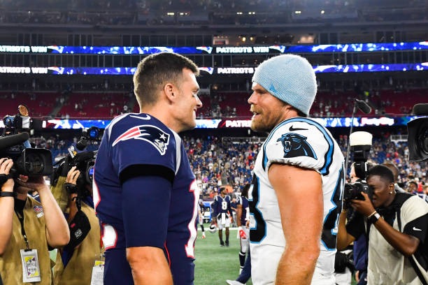 Tom Brady of the New England Patriots meets with Greg Olsen of the Carolina Panthers following the Patriots 10-3 preseason victory at Gillette...