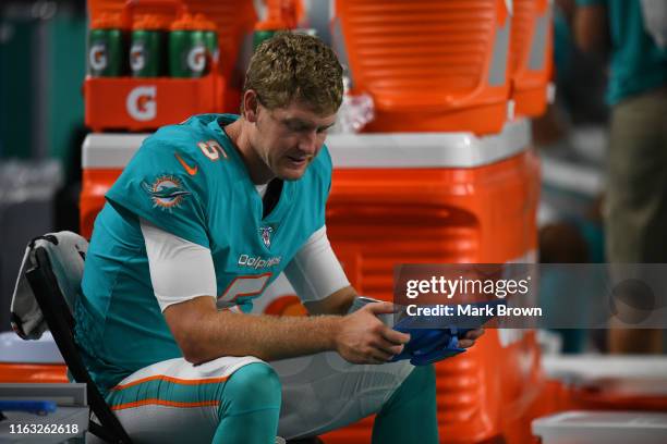 Jake Rudock of the Miami Dolphins looks at a tablet in the fourth quarter during the preseason game against the Jacksonville Jaguars at Hard Rock...