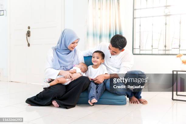 beautiful young family with spending time in house - cute muslim boys stock pictures, royalty-free photos & images