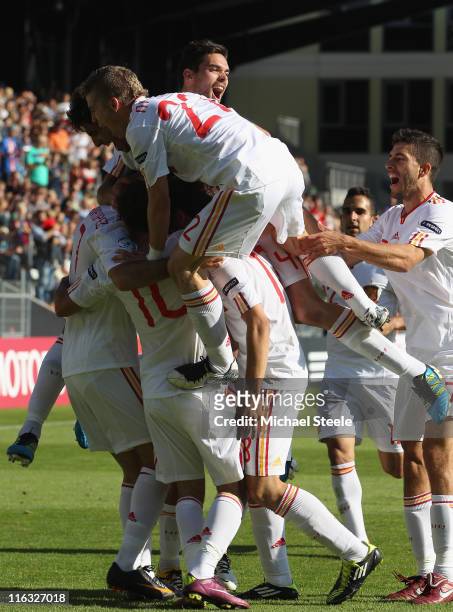 Iker Muniain of Spain jumps on his team mates to celebrate the first goal scored by Adrian during the UEFA European Under-21 Championship Group B...