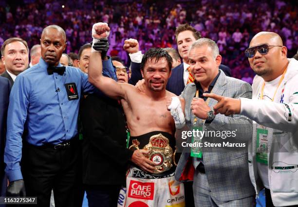 Manny Pacquiao poses with members of his team and referee Kenny Bayless after defeating Keith Thurman by split decision in a WBA welterweight title...