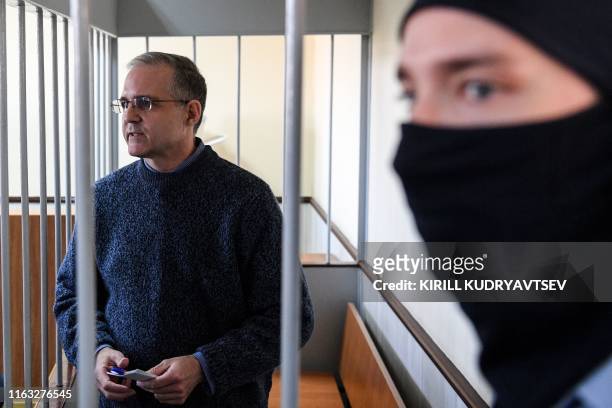 Paul Whelan, a former US Marine accused of spying and arrested in Russia stands inside a defendants' cage during a hearing at a court in Moscow on...