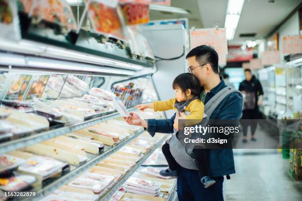 young asian father grocery shopping with cute little daughter in supermarket, they are shopping for fresh poultry - baby chicken bildbanksfoton och bilder