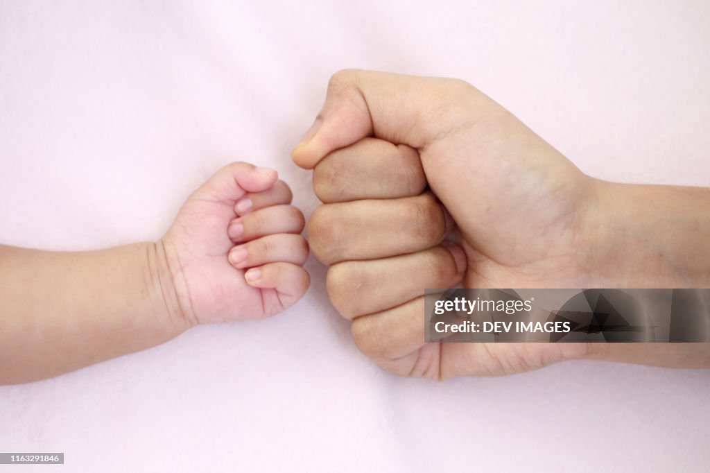 Fist of mother and baby close up