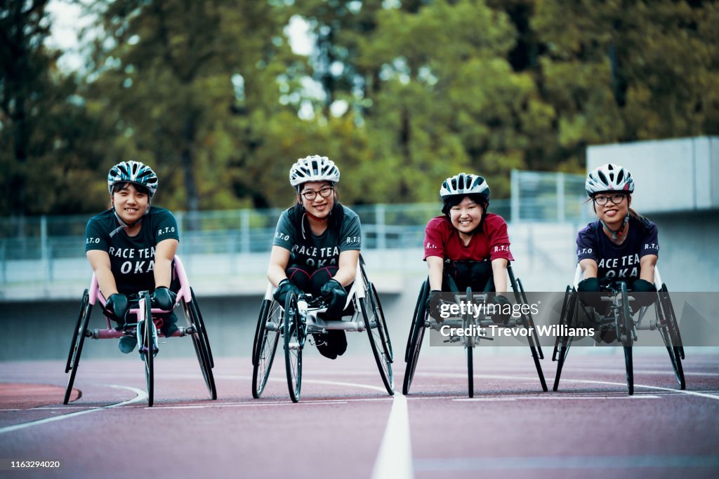 Young female wheelchair racers prepare for competition at a track and field event