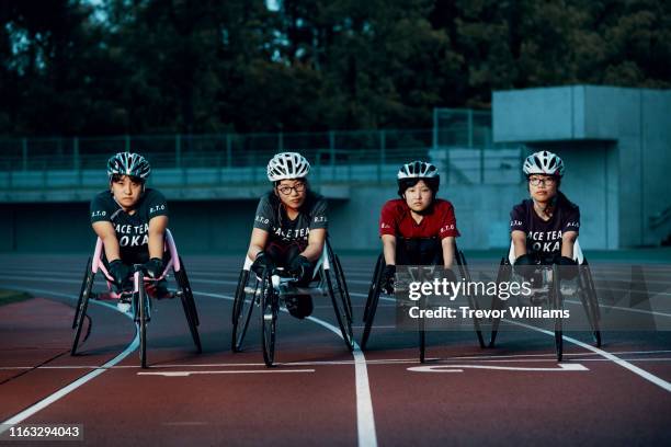 young female wheelchair racers prepare for competition at a track and field event - paraplegic woman photos et images de collection