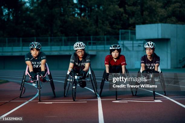 young female wheelchair racers prepare for competition at a track and field event - protective sportswear stock pictures, royalty-free photos & images