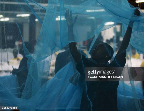 Workers inspects a mosquito bed net as US President George W. Bush and First Lady Laura Bush tour the A to Z Textile Mills on February 18, 2008 in...