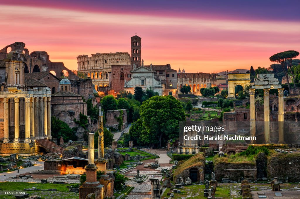 Colosseum and Forum Romanum with triumphal arches at sunrise, Rome, Lazio, Italy