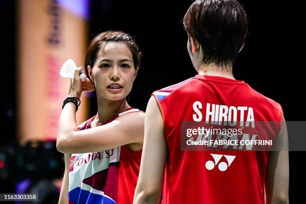 Japan's Yuki Fukushima reacts next to Japan's Sayaka Hirota during their women's doubles quarter-final match against South Korea's Shin Seung Chan...