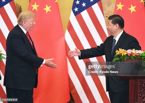 President Donald Trump and his Chinese counterpart Xi Jinping shake hands during a joint press conference at the Great Hall of the People in Beijing...