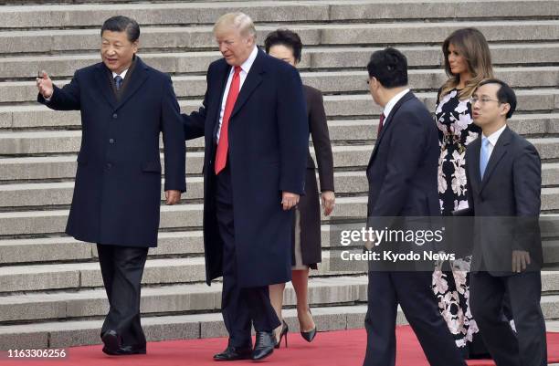 President Donald Trump and his Chinese counterpart Xi Jinping , along with Trump's wife Melania , attend a welcome ceremony in Beijing on Nov. 9,...