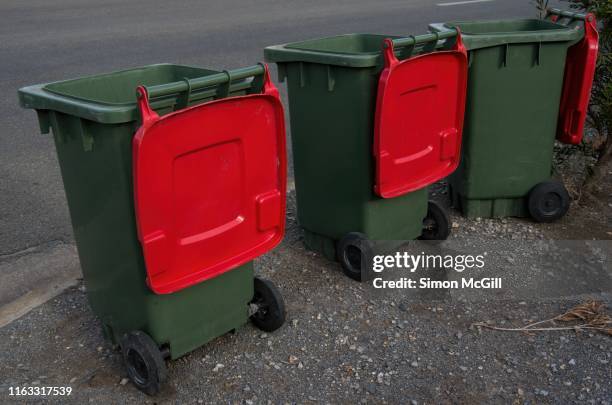 plastic wheeled rubbish bin beside the road for rubbish collection - kerb stock pictures, royalty-free photos & images