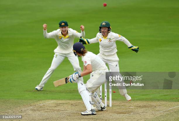 Natalie Sciver of England is bowled by Jess Jonassen of Australia as Meg Lanning and Alyssa Healy of Australia celebrate during day four of the Kia...