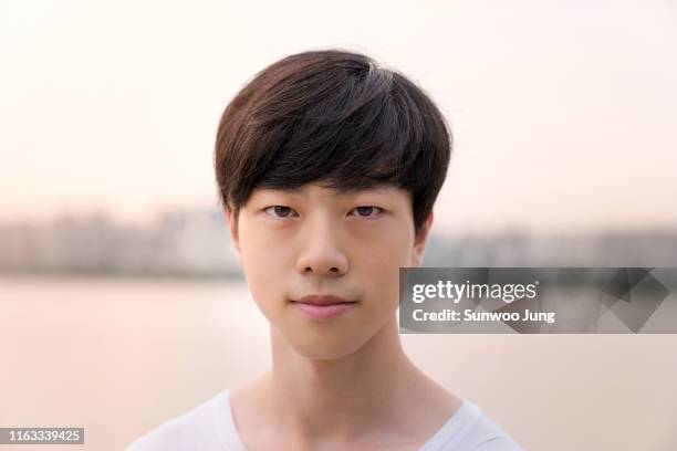 portrait of man looking at camera outdoors - korean man stockfoto's en -beelden