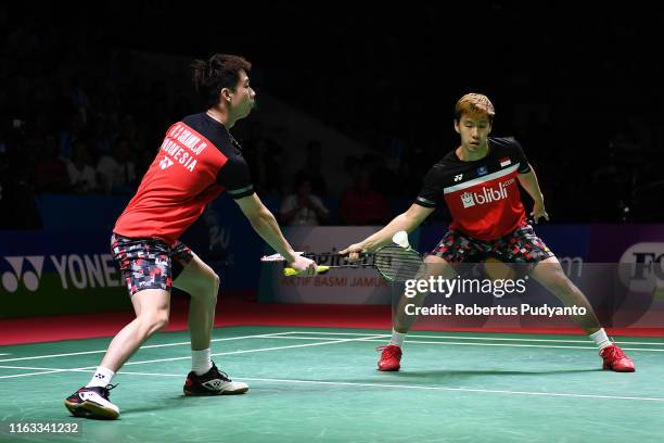 Marcus Fernaldi Gideon and Kevin Sanjaya Sukamuljo of Indonesia compete against Mohammad Ahsan and Hendra Setiawan of Indonesia during the Mens...