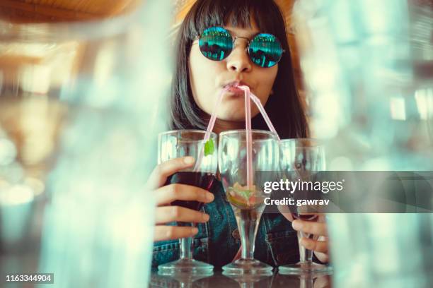 ung kvinna dricker tre glas mock-tail på en gång. - cocktail and mocktail bildbanksfoton och bilder