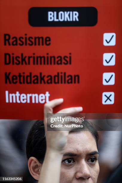 An Indonesian activist holds a poster calling for government unblocks the internet in West Papua during a demonstration protesting the Ministry of...