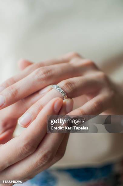 a close-up view of a young woman wearing a wedding ring - taking off wedding ring stock pictures, royalty-free photos & images