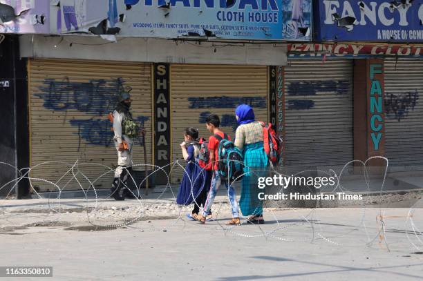 Children go for their tuitions as security personnel stand guard, on August 23, 2019 in Srinagar, India. Restrictions were imposed in Srinagar city...