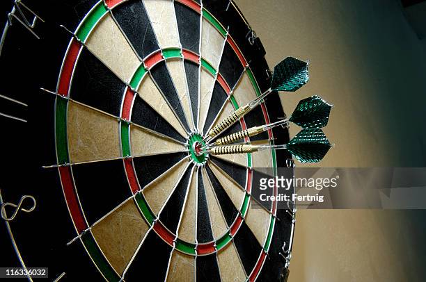 three darts on a bullseye - darts stockfoto's en -beelden