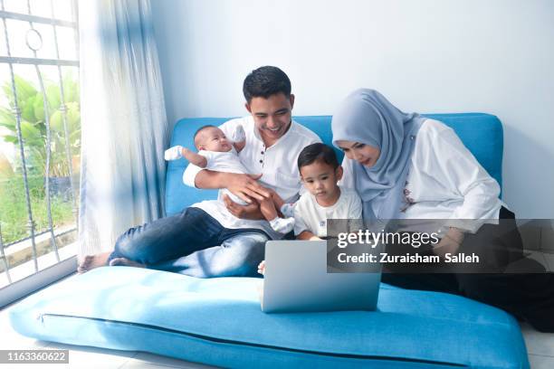 malaysian family using laptop together at home - malaysia family stock pictures, royalty-free photos & images