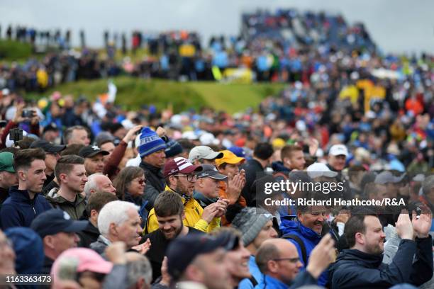 Crowd reacts to a putt by Shane Lowry of Ireland on the 13th green during the final round of the 148th Open Championship held on the Dunluce Links at...