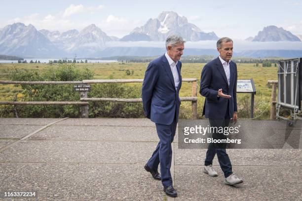 Jerome Powell, chairman of the U.S. Federal Reserve, left, and Mark Carney, governor of the Bank of England , walk the grounds during the Jackson...