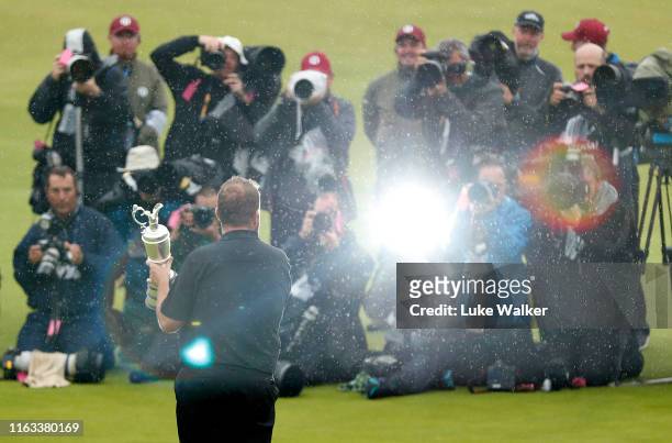 Photographers surround Open Champion Shane Lowry of Ireland as he celebrates with the Claret Jug on the 18th green during the final round of the...