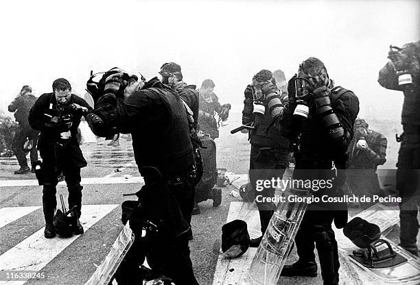 Police wear gas masks before a charge during an anti-globalization protest against the 27th G8 Summit In Genoa, on July 21, 2001 in Genoa, Italy....
