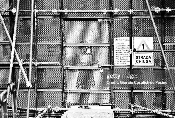 Woman tries to look through the fence enclosing the red zone, prior the beginning of the protest against the 27th G8 Summit In Genoa, on July 21,...