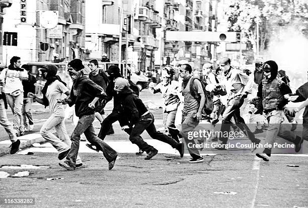 Activists of the anti-globalization movement run away from a police charge during a protest against the 27th G8 Summit In Genoa, on July 21, 2001 in...