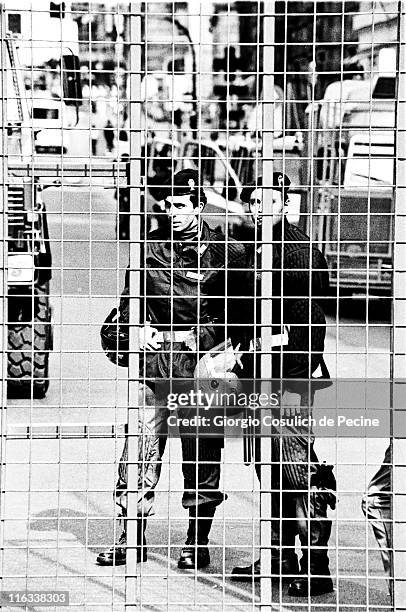 Police officers monitor the red zone surrounded by a fence, prior the beginning of the protest against the 27th G8 Summit In Genoa, on July 21, 2001...