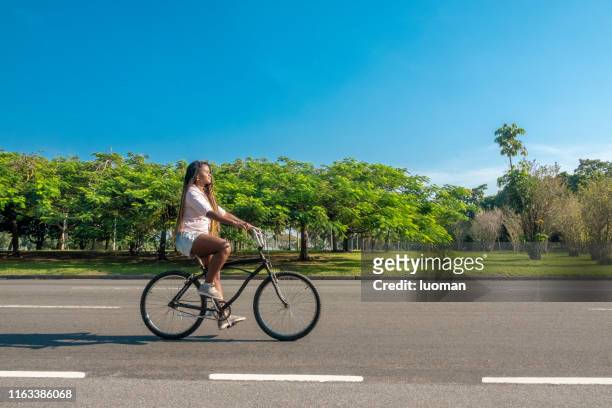 beautiful black brazilian woman riding a bicycle - flamengo park stock pictures, royalty-free photos & images