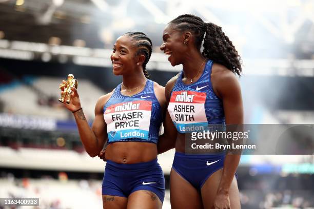 Shelly-Ann Fraser-Pryce of Jamaica and Dina Asher-Smith of Great Britain share a joke after the Women's 100m Final during Day Two of the Muller...