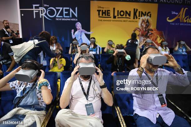 Attendee try the Disney on Broadway virtual reality experience at the D23 Expo, billed as the "largest Disney fan event in the world," August 23,...