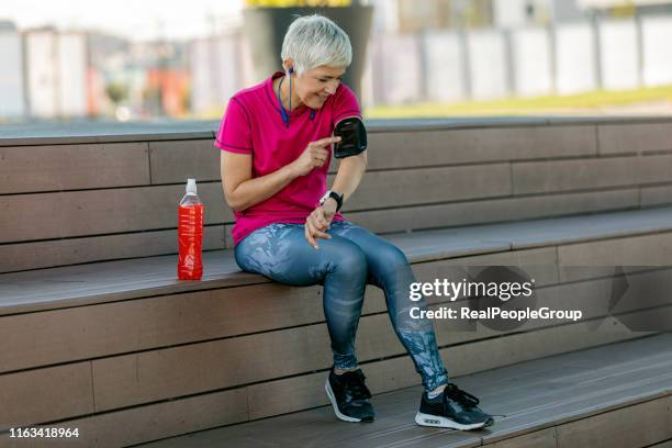 senior sports woman checking pulse on mobile app . - a v pacemaker stock pictures, royalty-free photos & images