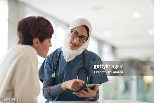muslimischer chirurg konsultiert patientin - arab doctor patient stock-fotos und bilder
