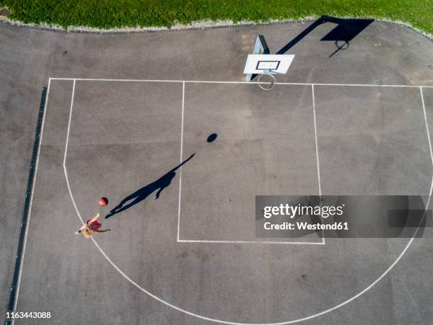 aerial view of young woman playing basketball - arremessar imagens e fotografias de stock